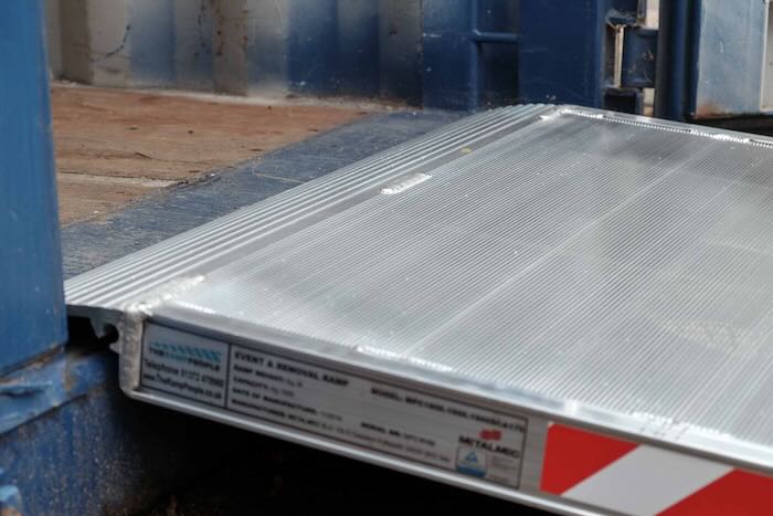 Pallet truck loading ramp resting on container Pallet truck loading ramp resting on container