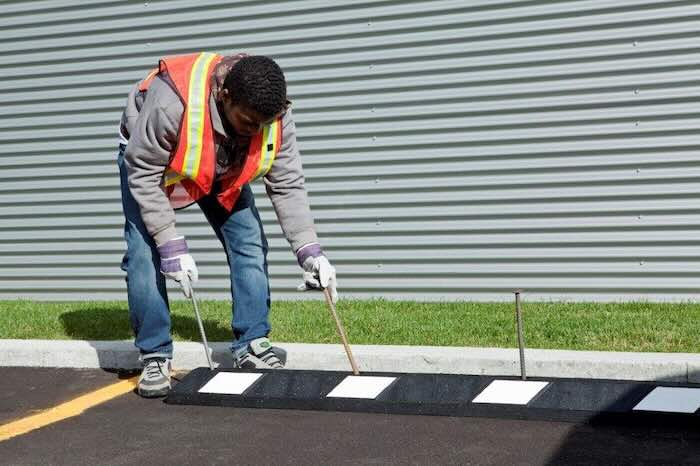 Man installed black and white wheel stop in car park Man installed black and white wheel stop in car park