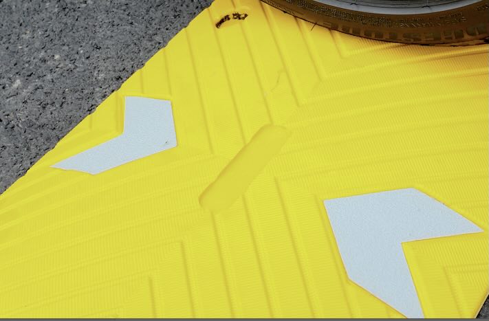 Yellow section of the speed bump with reflective chevrons Yellow section of the speed bump with reflective chevrons