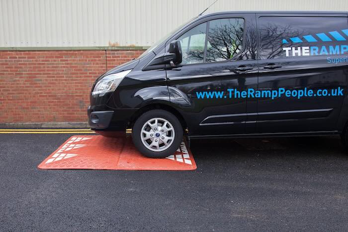 Van driving over red speed cushion Van driving over red speed cushion