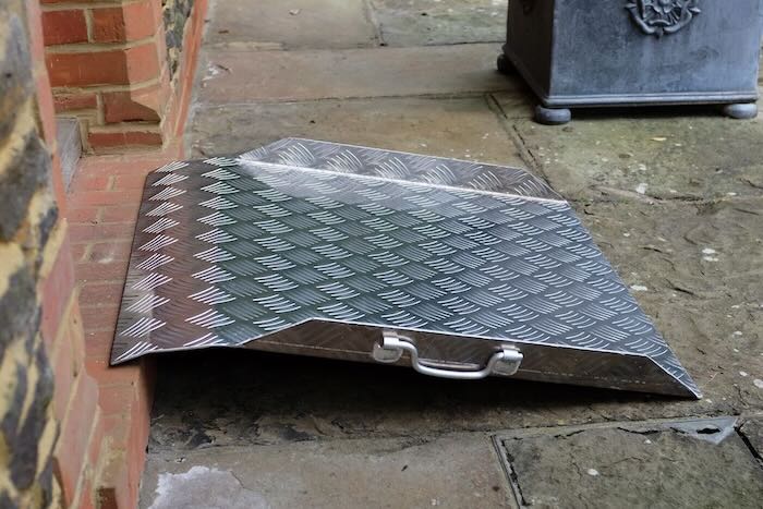Aluminium threshold ramp resting on step