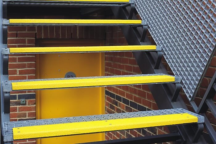 Yellow anti-slip stair treads on steel staircase fire exit 