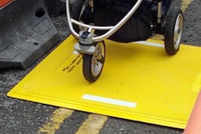 Buggy going over yellow trench cover