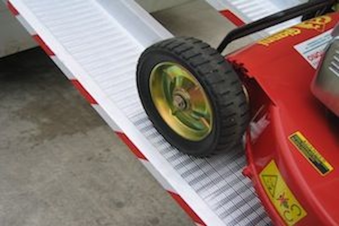 Lawnmower going up pair of aluminium loading ramps Lawnmower going up pair of aluminium loading ramps