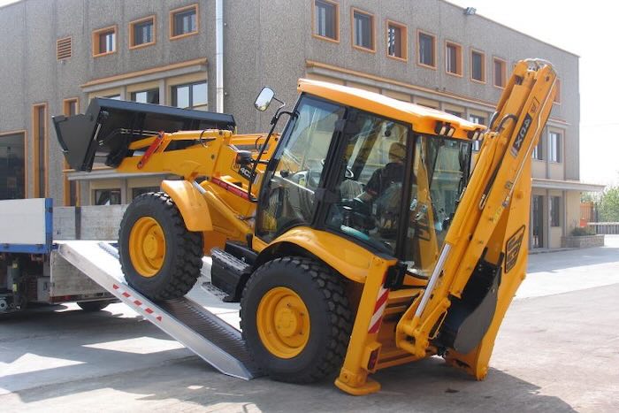 JCB driving up pair of aluminium loading ramps JCB driving up pair of aluminium loading ramps